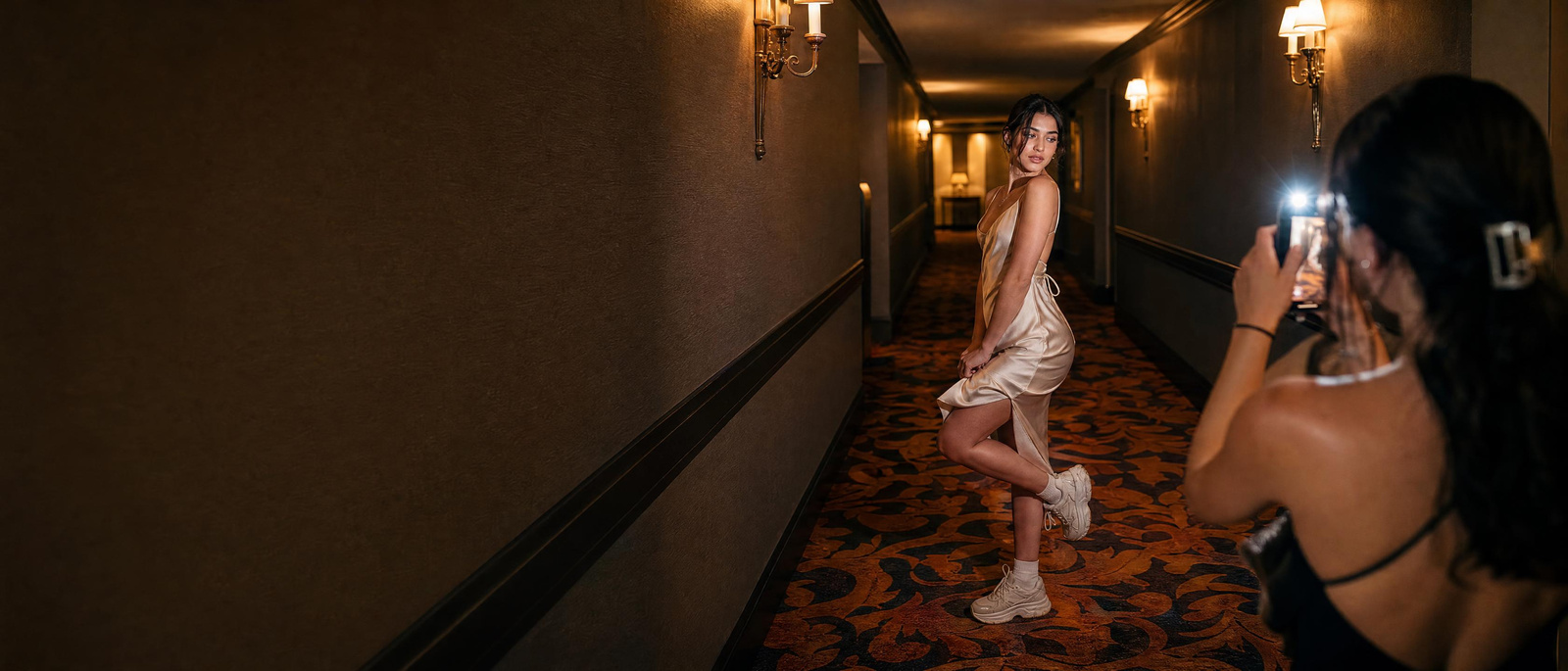 A young creator posing in a hotel corridor with flash