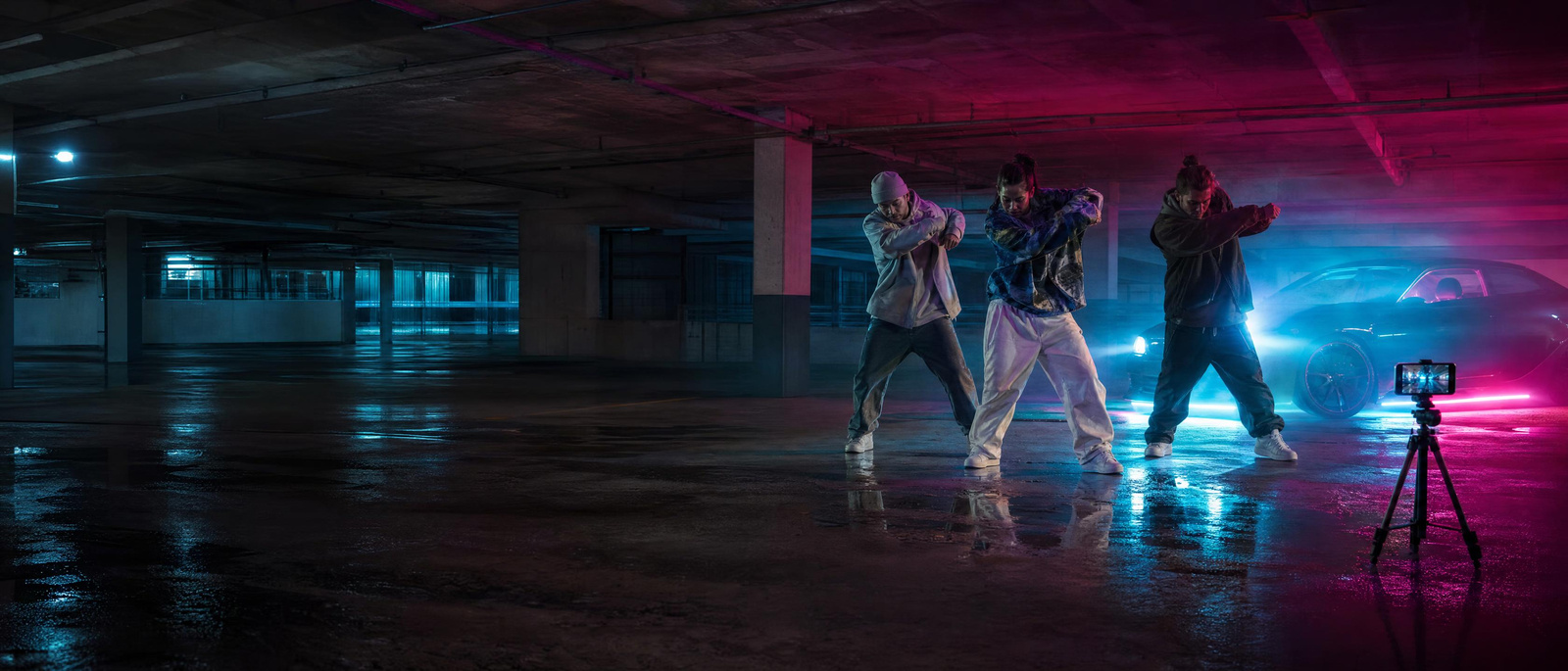 Friends filming a dance trend in a parking garage at night