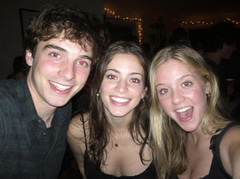 Three friends at a night party photographed with a direct on-camera flash, red-eye in every eye