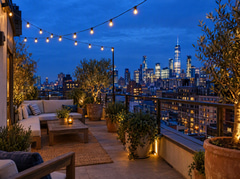 Rooftop terrace overlooking a city at blue hour