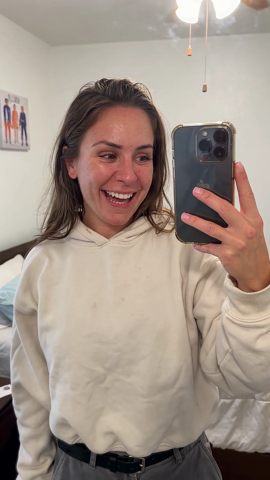 A bedroom mirror clip edited so the woman wears an oversized cream hoodie and grey cargos, with the same moves