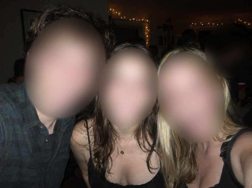 After: Three friends at a night party photographed with a direct on-camera flash, red-eye in every eye — faces blurred