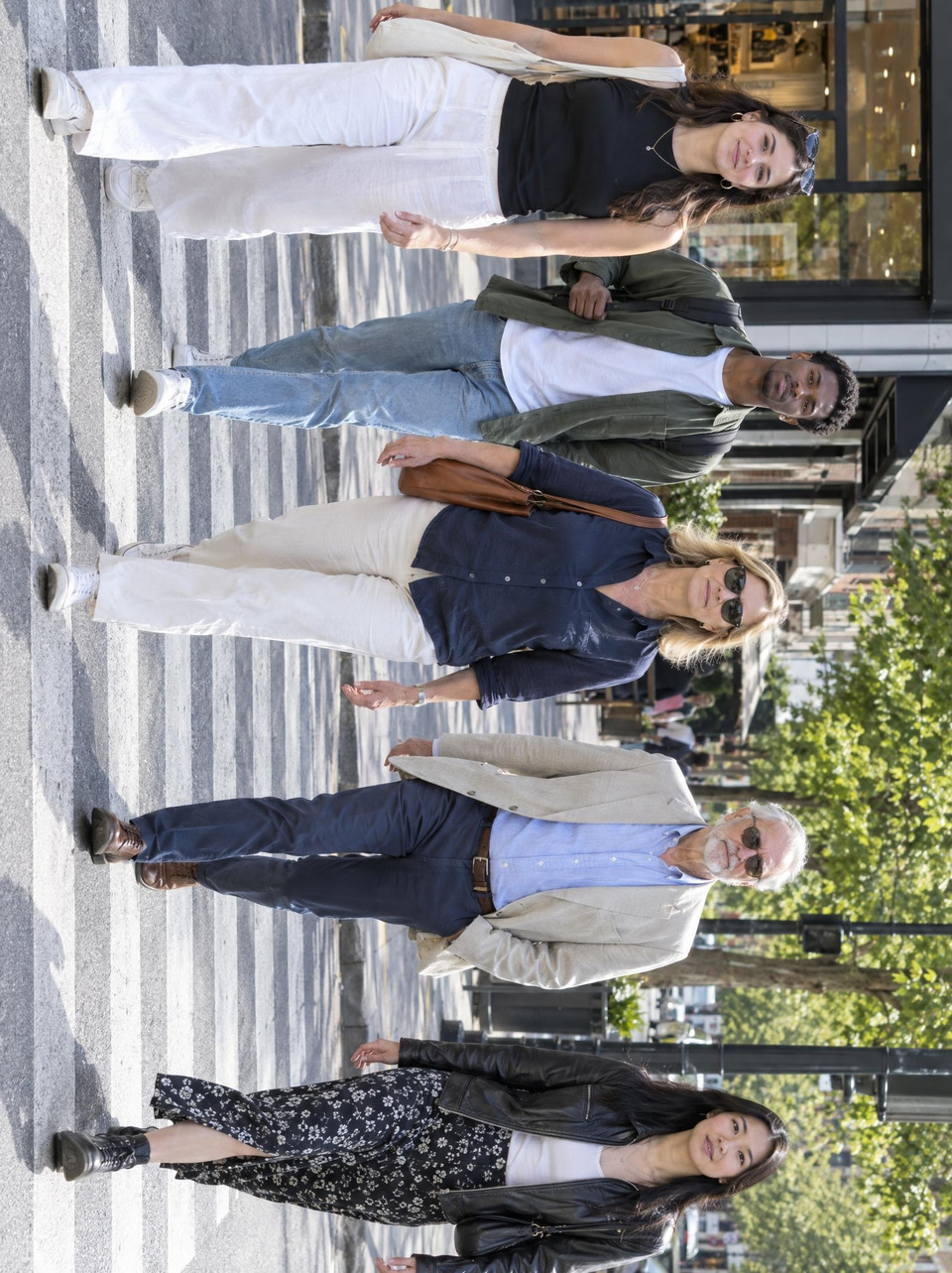 After: Pedestrians crossing a sunny city street, several faces towards the camera — rotated