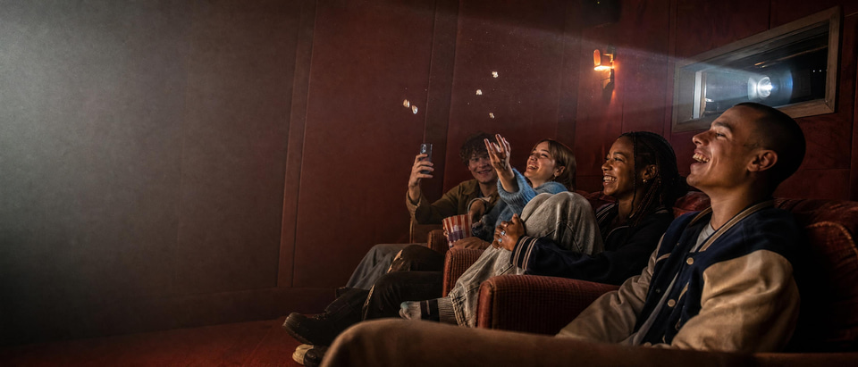 Friends watching their finished short film in a small screening room
