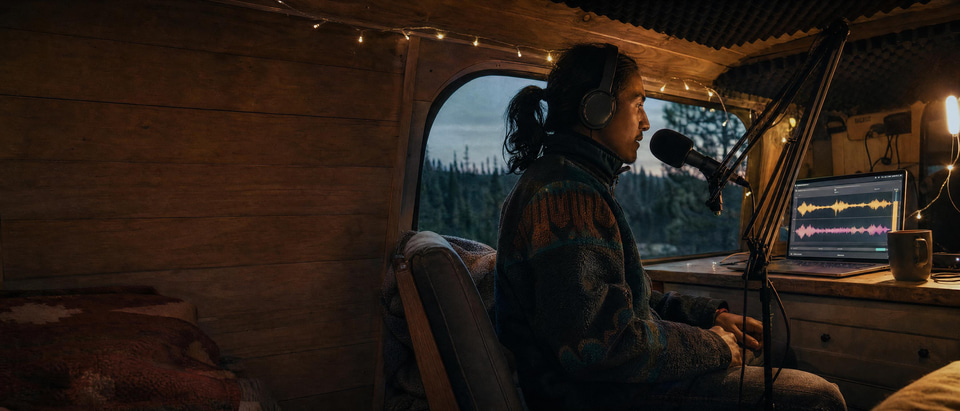 A podcaster in a converted van changing the voice in his recording