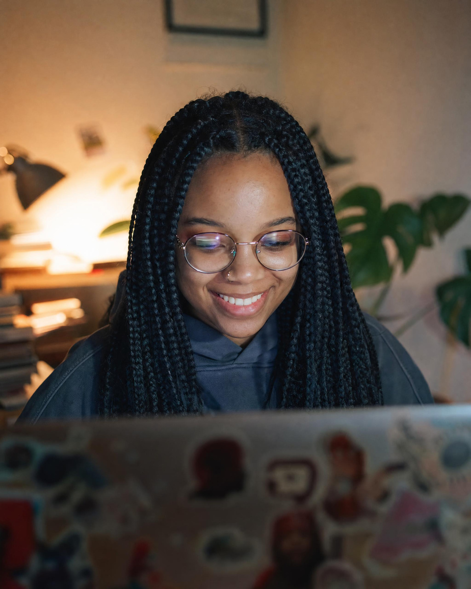 A young developer smiling at her screen