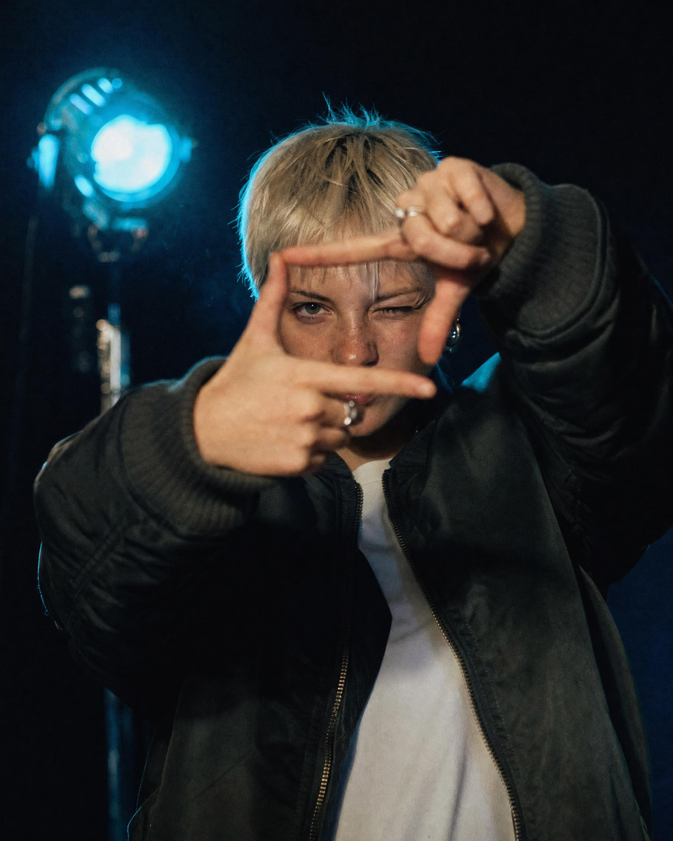 A young director framing a shot with her hands
