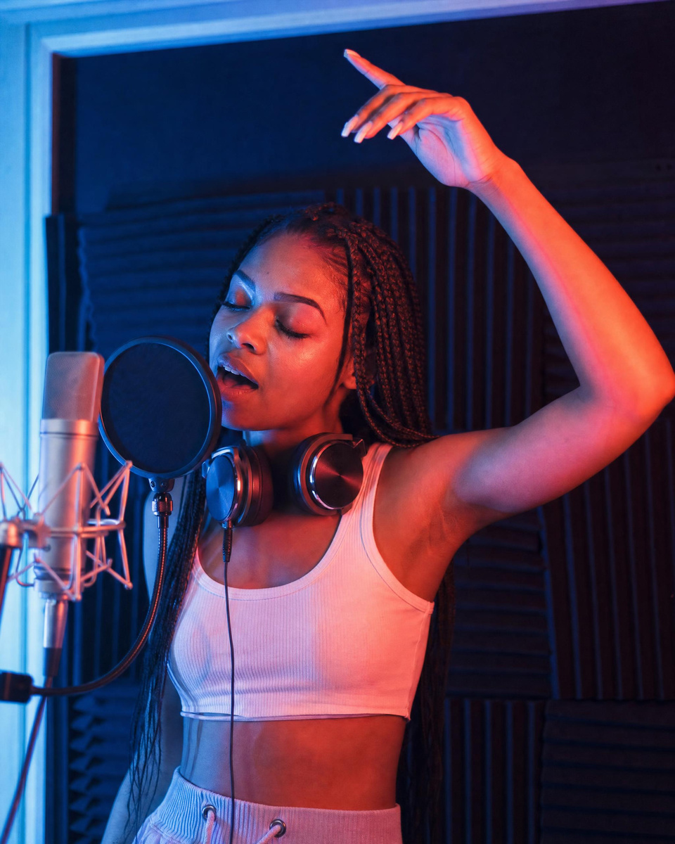 A young singer at the microphone in a neon booth