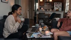Two friends chatting over coffee on a living-room sofa